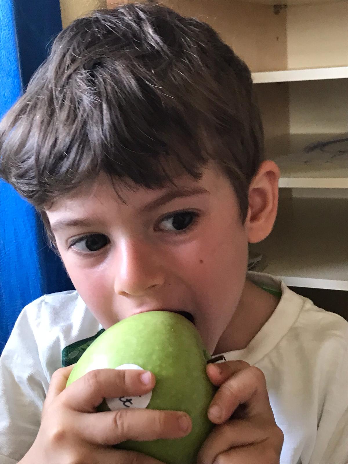 bambino che mangia una mela